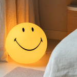 Lampe boule smiley sur une étagère